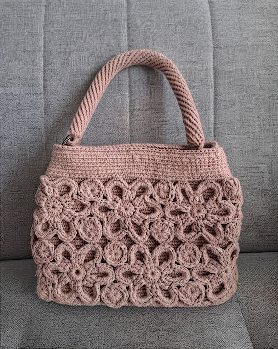 Bolsa de crochê rosa claro vista de frente, com alça erguida